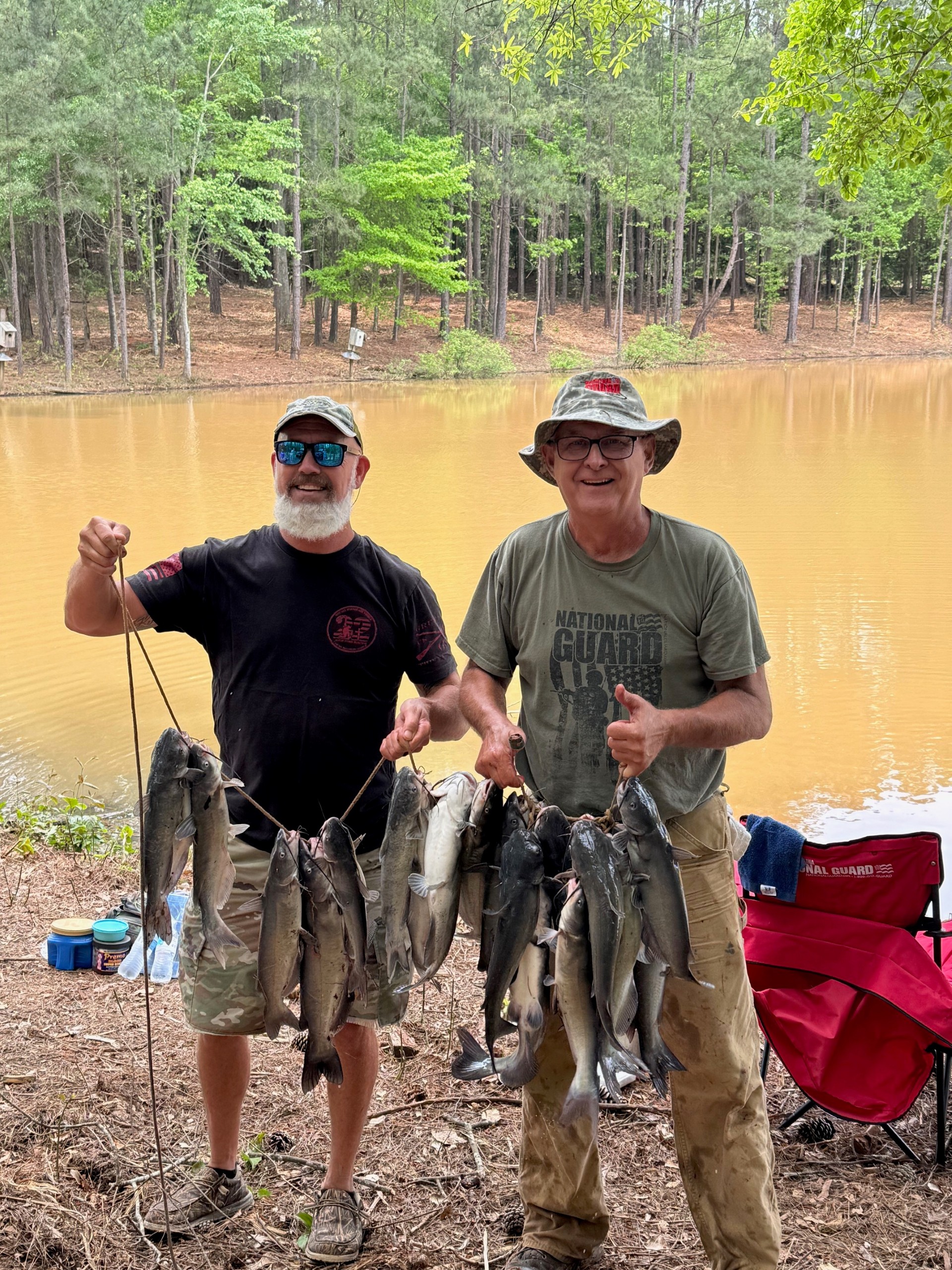 two fishermen holding up their catch of catfish